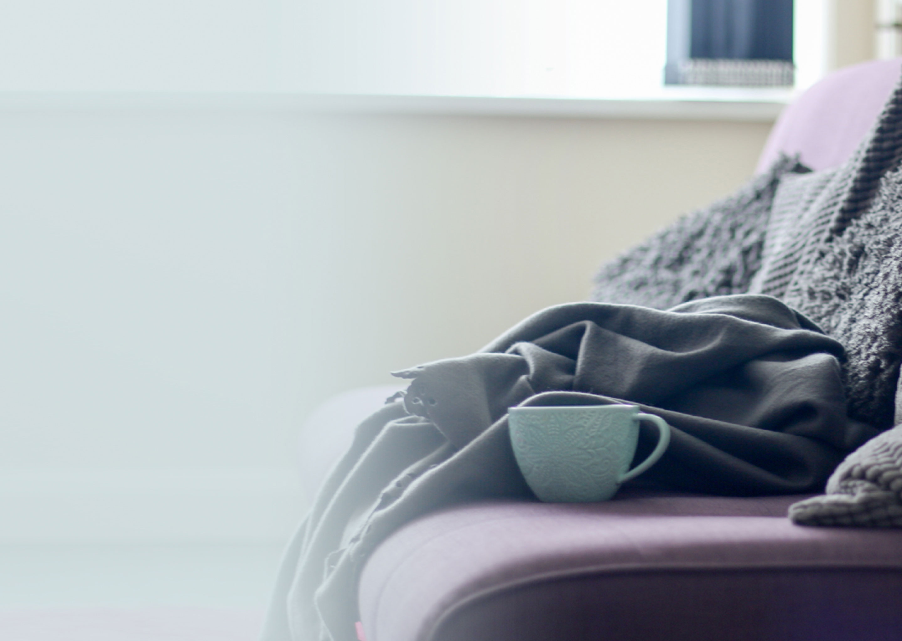 blanket and coffee cup on couch